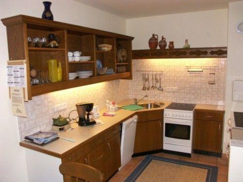 兰格尔斯道夫Ferien-am-Bauernhof-Wohnung-3的厨房配有木制橱柜和白色的电器