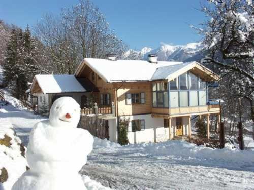 兰格尔斯道夫Ferien-am-Bauernhof-Wohnung-3的站在房子前面的雪人