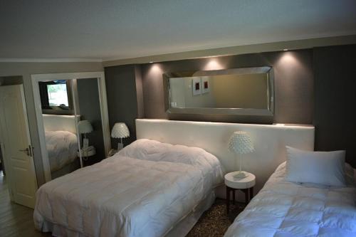 埃斯特角城Forest Lagoon Apartamento 6的一间卧室配有两张床和镜子