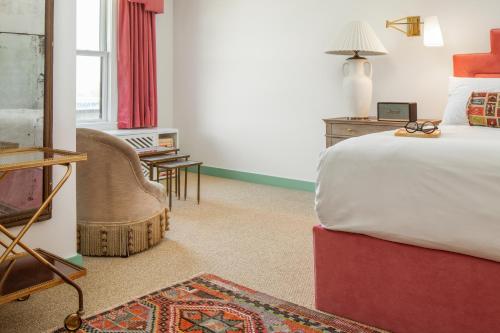 俄克拉何马城Bradford House, a Member of Design Hotels的一间卧室配有一张床、一把椅子和一张桌子