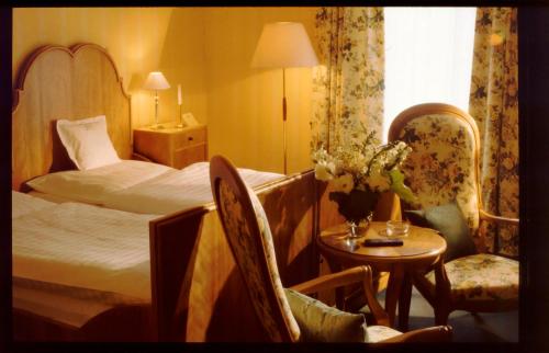 Laubach格贝尔咖啡我们的小酒店的酒店客房带一张床、一张桌子和椅子