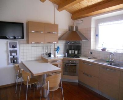 努马纳Appartamento sulla Riviera del Conero的厨房配有桌椅和电视。