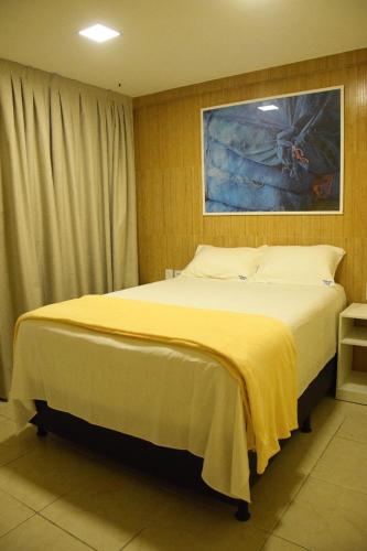 纳塔尔Ana marinho flat 702的一间卧室配有一张带黄色毯子的大床