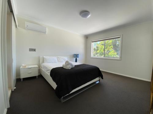 汤斯维尔Townsville Wistaria Spacious Home的白色的卧室设有床和窗户