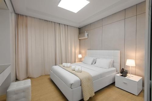 阿斯塔纳Elite apartments的一间卧室配有一张白色床,上面有两根蜡烛