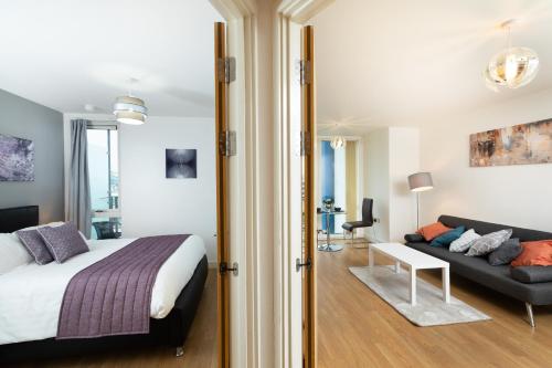 米尔顿凯恩斯Brightleap Apartments - The Hub的一间卧室配有一张床和一张沙发