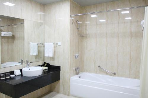 卢萨卡赞比亚金孔雀酒店的一间带水槽、浴缸和卫生间的浴室