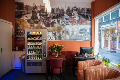 阿姆斯特丹Hotel Continental Amsterdam的一间设有冰箱和壁画墙的房间