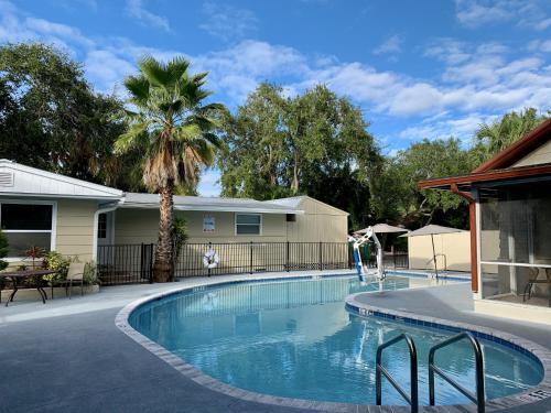 西耶斯塔岛Siesta Heron Suites & Villas的棕榈树屋前的游泳池