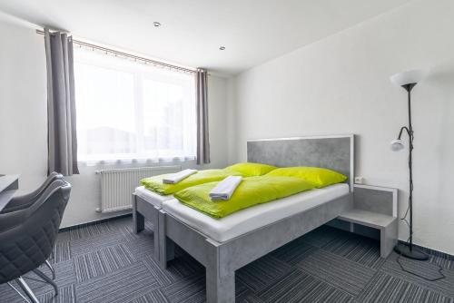 斯皮什新村Garni Hotel 31的一间卧室配有一张带黄色枕头的床和一扇窗户