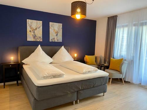 霍兹哈森蓝哥罗迷宾馆的一间卧室设有一张大床和蓝色的墙壁