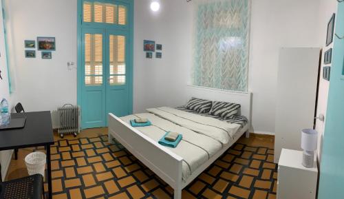 海法Apartments COMFY - for a quiet family holiday的一间卧室配有一张带蓝色门的床和一张书桌