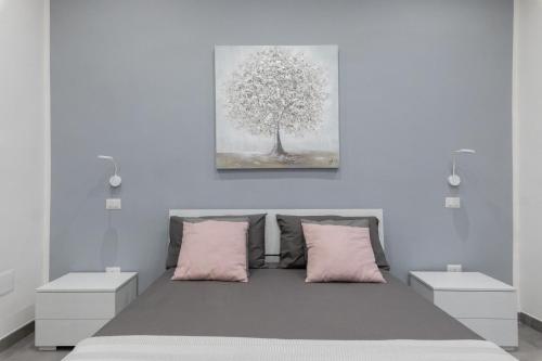 那不勒斯Dante Square的一间卧室配有带粉红色枕头和一棵树的床。