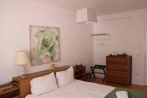 洛萨Casa Sandra - Apartamento Carlota的卧室配有一张床,墙上挂有绘画作品