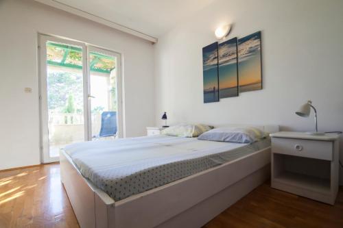波尔Apartments Radić的白色的卧室设有一张大床和一个窗户