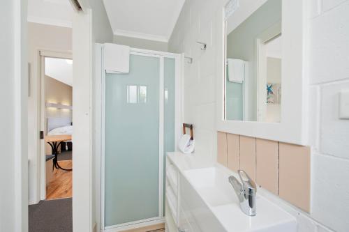 阿波罗湾马兰高汽车旅馆的白色的浴室设有水槽和镜子