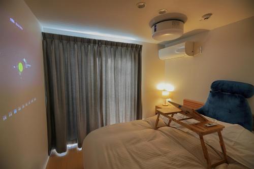 富士河口湖Fujiyasan的一间卧室配有一张床和一张蓝色椅子