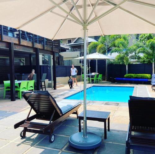 巴利托Billfish Apartments的游泳池旁设有椅子和遮阳伞的游泳池