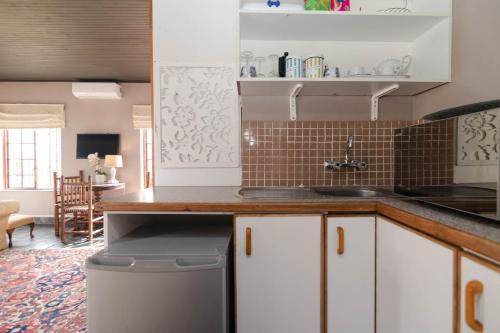 斯泰伦博斯Boord Guest House的厨房配有白色橱柜和台面