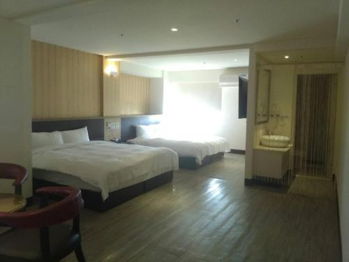 虎尾镇登丰米兰商务旅店的酒店客房带两张床和一间浴室