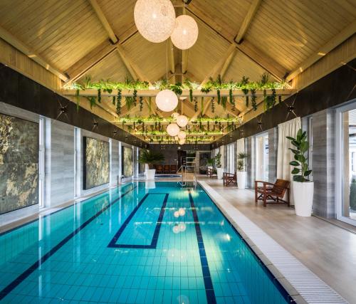 沙罗什保陶克Hotel Bodrog Wellness & Elix Spa的大楼内一个蓝色瓷砖的大型游泳池