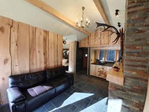 阿祖加Alpin Lodge的客厅设有真皮沙发和砖墙