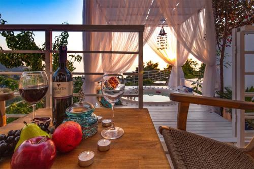 法拉尔雅Highclere Hotel and Spa的一张木桌,上面放着两杯葡萄酒和水果