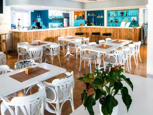马略卡岛帕尔马利斯马洛卡酒店的一间设有白色桌子和白色椅子的餐厅