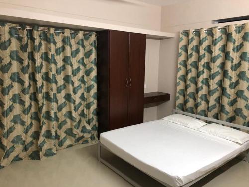 特里凡得琅Nachiyar Suites的一间卧室配有床和窗帘