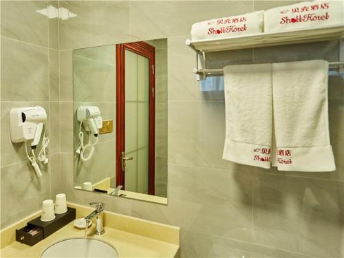 芜湖贝壳芜湖市镜湖区万达广场康复路酒店的浴室配有盥洗盆、镜子和毛巾