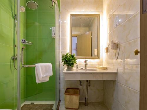 常州格林豪泰常州邹区镇泰富时代广场振中路快捷酒店的浴室配有盥洗盆和带镜子的淋浴