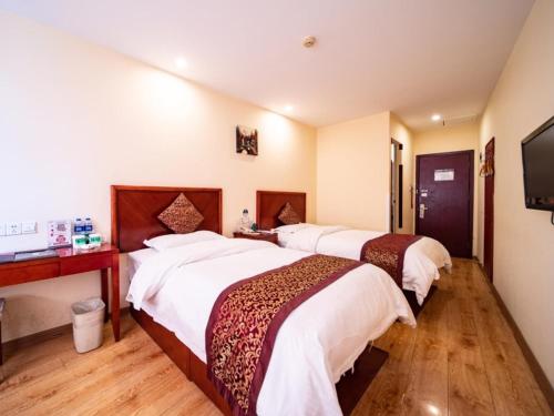 天津格林豪泰天津市华苑科园商务酒店的酒店客房设有两张床和一台平面电视。