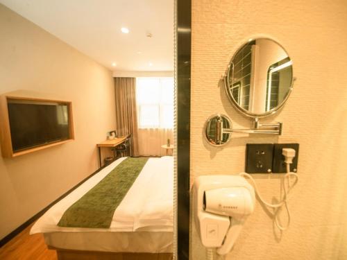 南京GreenTree Inn Nanjing Lukou Airport的酒店客房,配有床和镜子
