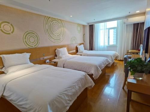 西宁格林豪泰西宁湟光莫家街快捷酒店的酒店客房,配有3张带白色床单的床