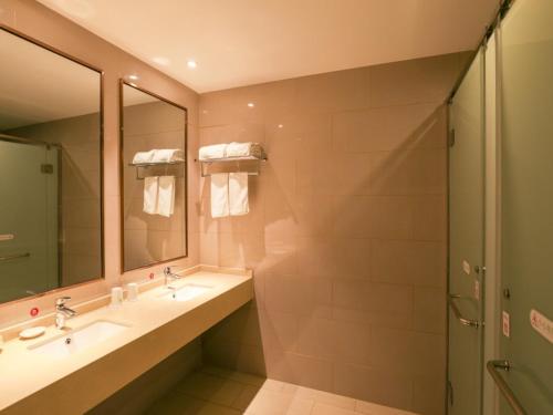 无锡格林豪泰无锡融创文旅城南泉镇商务酒店的一间带两个盥洗盆和淋浴的浴室