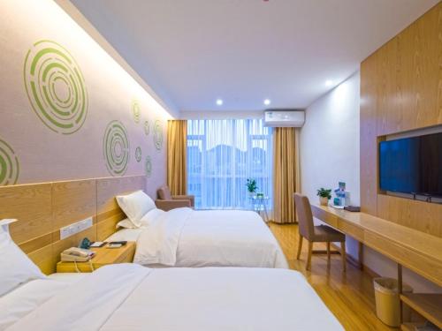 安顺格林豪泰安顺西航路商务酒店的酒店客房设有两张床和一台平面电视。