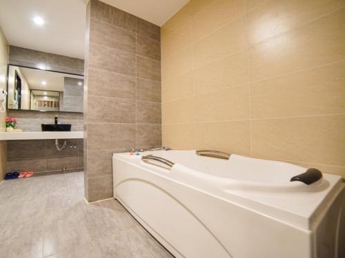 昆明格林联盟昆明北京路霖雨桥地铁站酒店的一间位于客房内的带白色浴缸的浴室