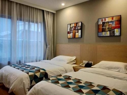 上海贝壳上海新国际博览中心芳华路地铁站酒店的酒店客房设有两张床和窗户。