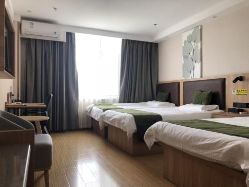 菏泽GreenTree Inn Heze Dingtao District Auto Town的酒店客房配有两张床和一张书桌