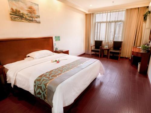 六安格林豪泰安徽省六安市磨子潭路义乌小商品市场商务酒店的酒店客房设有一张大床和一张书桌。