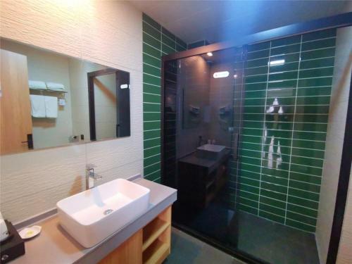 菏泽GreenTree Inn Heze Dingtao District Auto Town的浴室配有水槽和绿色瓷砖淋浴