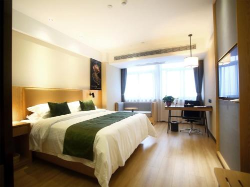 阜阳格林豪泰阜阳市会展中心商务酒店的一间卧室配有一张大床和一张书桌