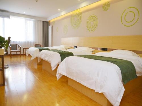 延庆县格林豪泰北京市延庆区八达岭长城康庄智选酒店的酒店客房,配有4张带白色床单的床