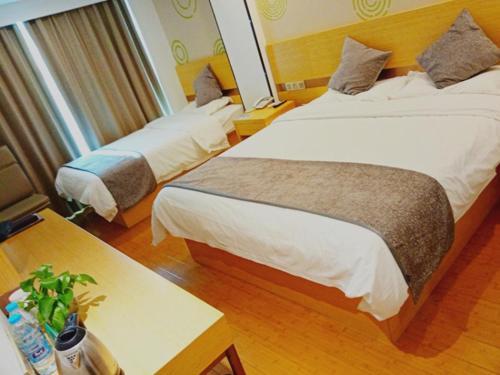 南京格林豪泰南京市省人民医院智选酒店的酒店客房设有两张床和一张桌子。