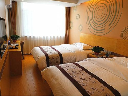 沈阳格林豪泰沈阳盛京医院滑翔地铁站商务酒店的酒店客房设有两张床和电视。