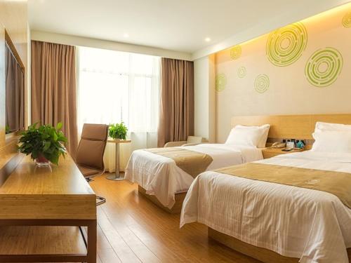 唐山格林豪泰唐山路北区爱琴海商务酒店的酒店客房设有两张床和窗户。
