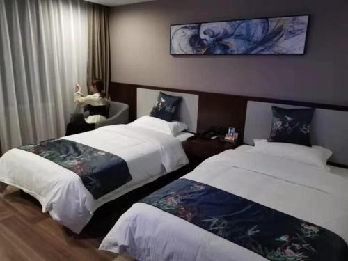 阜阳贝壳阜阳市汽车南站酒店的酒店客房设有两张床,窗户上有一个女人