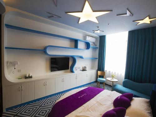 玉林格林豪泰玉林会展中心大润发酒店的卧室配有一张床,天花板上有一星星星