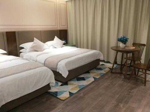 淮南格美淮南田家庵区朝阳东路酒店的酒店客房带两张床和一张桌子以及椅子。
