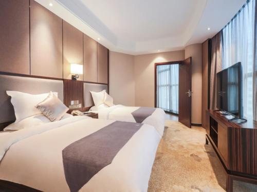 赣州格林东方赣州市章贡区八一四大道汽车站酒店的酒店客房设有两张床和一台平面电视。